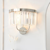 Calverdale Cut 2 light wall light in bright nickel with tiered faceted cut glass shades, illuminated on a white wall beside a mirror.