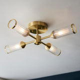 Gorsewell Ribbed Semi-flush 4 Light ceiling light by Lighting No.1 with satin brass sputnik arms and ribbed frosted glass shades on a white ceiling.