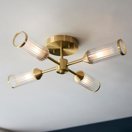 Gorsewell Ribbed Semi-flush 4 Light ceiling light by Lighting No.1 with satin brass sputnik arms and ribbed frosted glass shades on a white ceiling.