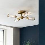 Gorsewell Ribbed Semi-flush 4 Light ceiling fitting in satin brass with frosted ribbed glass shades, mounted on a white ceiling beside a navy wall.