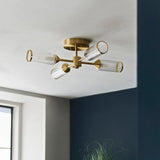 Gorsewell Ribbed Semi-flush 4 Light ceiling fitting in satin brass with frosted ribbed glass shades, mounted on a white ceiling beside a navy wall.