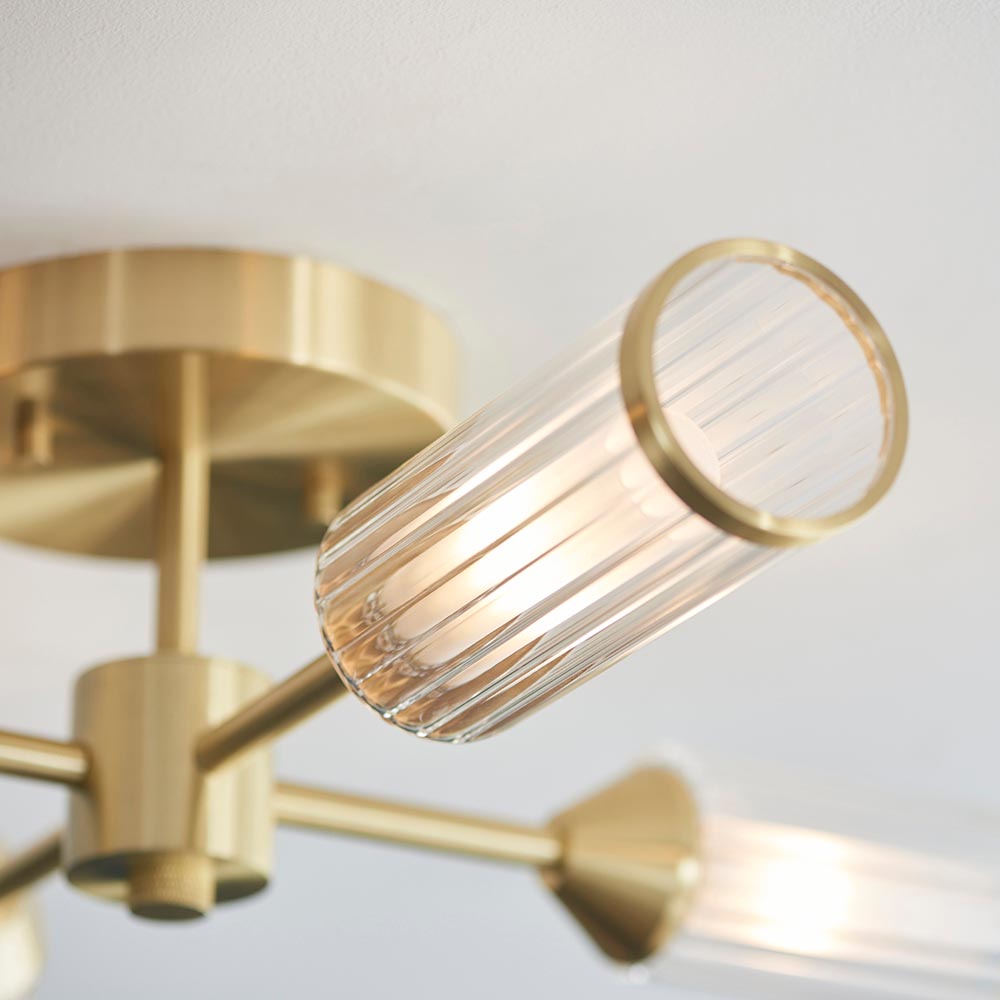 Close-up of Lighting No.1 Gorsewell Ribbed Semi-flush 4 Light ceiling light, showing satin brass arms and a ribbed frosted glass cylinder shade.