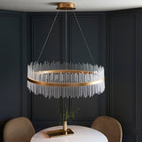 Rookhurst Rod Grand Pendant in gold by Lighting No.1, a wide ring of clear glass rods suspended above a marble dining table in a panelled room.