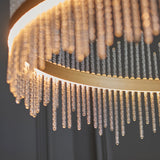 Close-up of the Lighting No.1 Rookhurst Rod Grand Pendant in gold, showing the curved gold frame and clear glass rods lit by warm integrated LED.