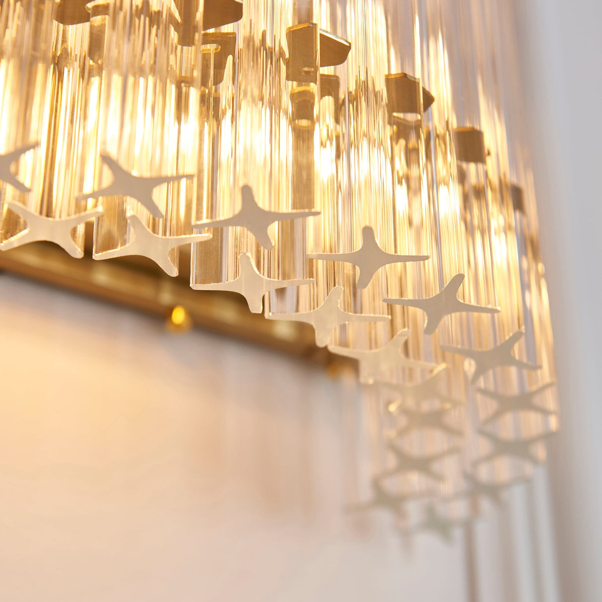 Close-up of the Lighting No.1 Nettlecote 2 Light Wall Light showing clear fluted glass shades set in a brushed aged brass frame.