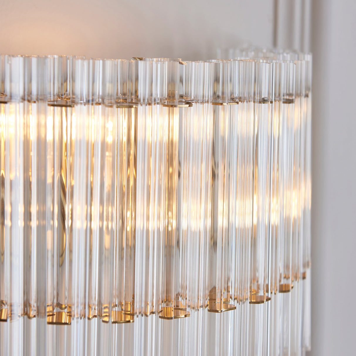 Close-up of Lighting No.1 Nettlecote 2 Light Wall Light showing clear ridged glass shades illuminated within a brushed aged brass frame.