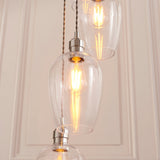 Quilbrook Cascade pendant by Lighting No.1 with clear glass globe shades and bright nickel fittings suspended at staggered heights with lit filament bulbs.