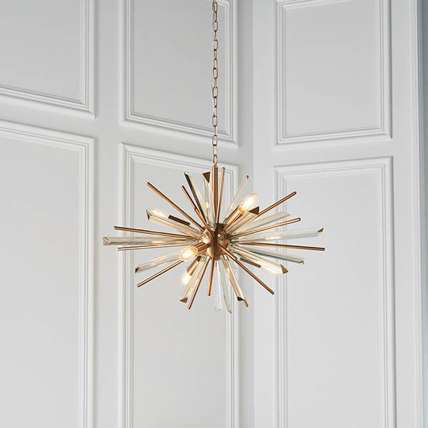 Selmoor Shards 6 light pendant from Lighting No.1 with antique brass plated arms and clear glass shards, suspended from a chain against white panelling.