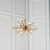 Selmoor Shards 6 light pendant from Lighting No.1 with antique brass plated arms and clear glass shards, suspended from a chain against white panelling.