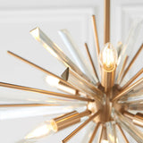 Close-up of Lighting No.1 Selmoor Shards 6 Light Pendant in antique brass plated finish, showing radiating arms, clear glass shards, and E14 candle bulbs.