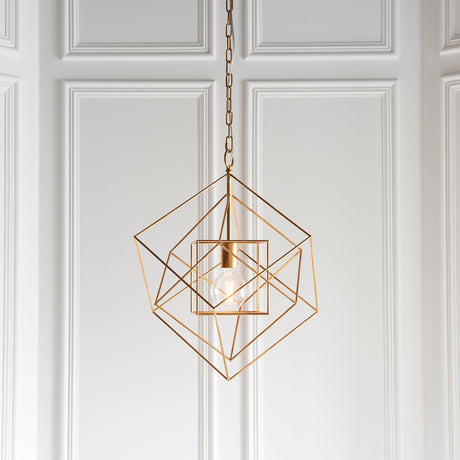 Padgrove Medium Angular Framed Single Pendant in gold leaf by Lighting No.1, hung on a chain against white panelled wall with exposed E27 bulb.