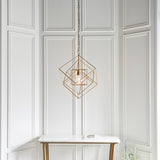 Padgrove Medium Angular Framed Single Pendant in gold leaf by Lighting No.1, hung on a chain above a marble console against white panelled walls.