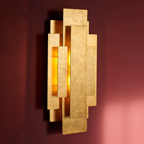 Dunmoor Rectangular Panel 2 Light Wall Light in gold by Lighting No.1, with layered metal rectangles glowing warmly against a deep red wall.
