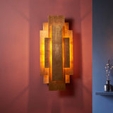 Dunmoor Rectangular Panel 2 Light Wall Light in gold by Lighting No.1, layered metal panels casting warm glow on a deep red wall.