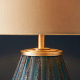 Close-up of the Lighting No.1 Foxleigh table lamp showing textured turquoise glass base, brushed gold cap and stem, beneath a cream shade.