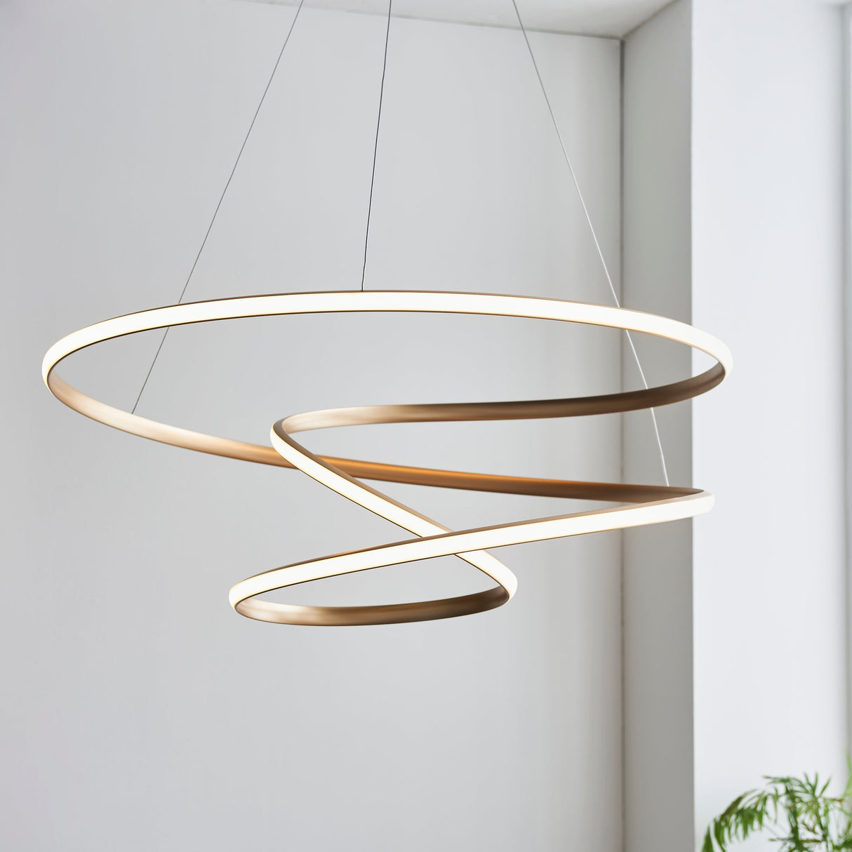 Lighting No.1 Tolmere Spiral Large Pendant in natural metal finish, coiled ribbon form hanging from thin cables in a bright neutral interior.