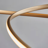 Close-up of the Lighting No.1 Tolmere Spiral Large Pendant in natural metal finish, showing the ribbon coiling with integrated LED glow along its inner edge.