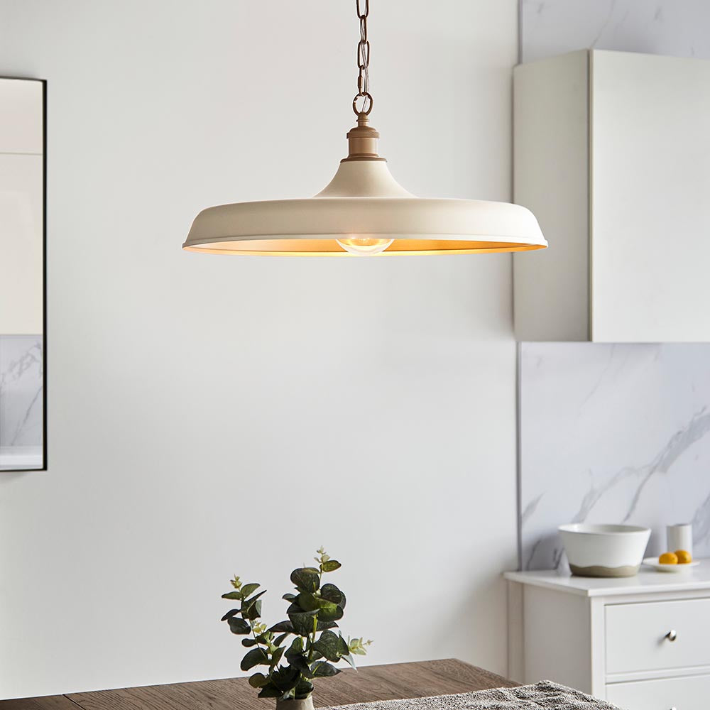 Denhollow Warm Mid Century Pendant in matt white satin with gold interior, hanging on a chain above a dining area with eucalyptus and marble.