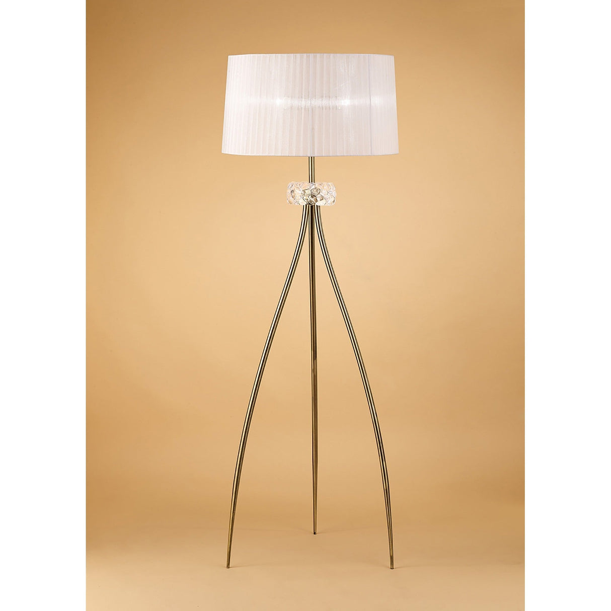 The Loewe 3 Light Floor Lamp - Brass With White Shade features a white pleated shade, clear glass accent, and gold legs for elegant lighting, shown against a beige background.