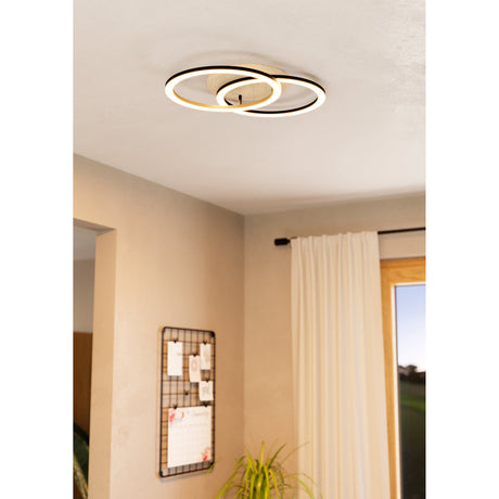 Lomaltas smart LED flush ceiling light with interlinked black rings and a round brown wood base, shown illuminated on a hallway ceiling.