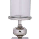 Longnah Candle Holder in polished silver aluminium with a bulb-shaped stem and round dish base, holding a clear glass cylinder, shown on a plain white background.