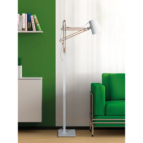 A modern, Scandinavian-inspired living room with a green sofa, the Looker 1 Light Wood Floor Lamp in matt white, a white cabinet with books, green and white walls, and light wood flooring.