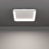 Loretello Smart LED Flush Ceiling Light, 35 x 35cm square fixture with rounded corners, white steel body and illuminated edge diffuser, mounted on a grey ceiling.
