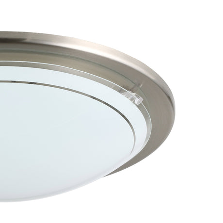 Close-up of the Lornette Flush Ceiling Light in satin nickel, showing the steel rim and domed white glass shade with a clear edge band, on a white background.