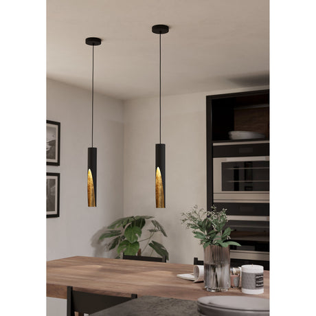 Losessa Pendant Light in matt black steel with gold leaf-textured lining, shown as two slim cylindrical pendants above a wooden dining table in a kitchen setting.