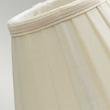 Close-up of the Clip Shades Pleated Ivory Candle Shade, showcasing its polycotton fabric and pleated design. This cylindrical lampshade's subtle texture stands out against a light gray background.