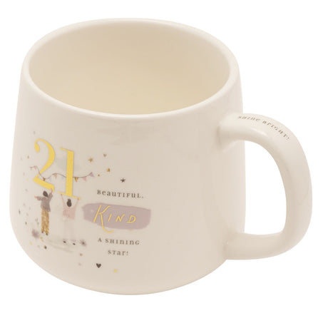 Cream stoneware mug for a 21st birthday, featuring a gold "21" with bunting, two illustrated figures, stars, and the text "Beautiful, kind, a shining star," on a plain white background.