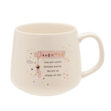 White stoneware mug with a pink Daughter banner in gold script, a swinging figure, cloud, and stars, reading You are loved beyond words. We are so proud of you.