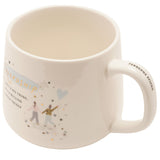 White stoneware mug with "Friendship" printed in gold over blue script, a heart balloon design and two walking figures, "Fabulous Friend" on the handle, shown on a plain background.
