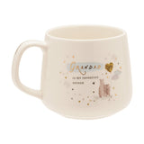 Cream stoneware mug with C-handle, reading "Grandad is my favourite person" in gold script over pale blue, beside bear illustrations and a gold heart balloon, on a white background.