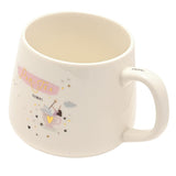 White stoneware mug with cream interior, featuring "Par-Tea Time" in gold script on a pink brushstroke, a tiny fairy in a teacup with gold heart and stars, handle reading "Enjoy!"