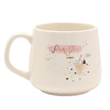 White stoneware mug with C-handle featuring "Par-Tea Time" in gold script on a pink brushstroke, a whimsical figure in a teacup, and scattered stars and hearts, shown on a plain white background.