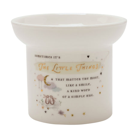 White round ceramic wax melt burner with a wide bowl top, printed with "The Little Things" quote in gold lettering, bunnies, moon and stars on a plain background.