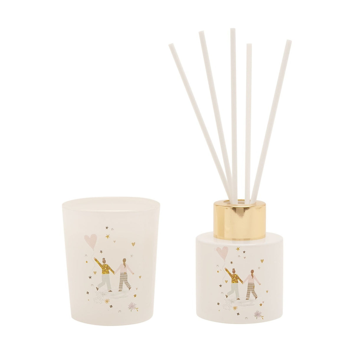 White glass mini reed diffuser with gold collar and five white reeds, paired with a matching frosted candle, both featuring a heart balloon couple illustration, on a plain white background.