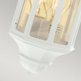 The Malaga Outdoor 1 Light Mini Wall Lantern in white is crafted from cast aluminium, featuring a clear glass enclosure that showcases an exposed light bulb against a light gray background. It has an IP54 rating and boasts a classic, angular design with a slightly tapered base.