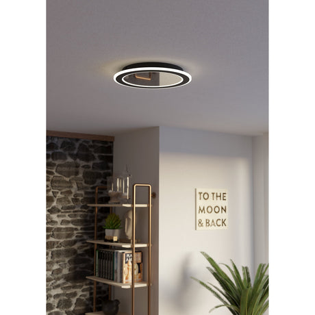 Macchioni LED flush ceiling light in black and white, round design with offset ring diffuser, mounted on a grey ceiling in a hallway setting.