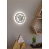 Macchioni LED Wall Light 20cm in white, round layered design with frosted outer ring and crystal-effect centre, glowing on a bedroom wall beside wooden shelving.