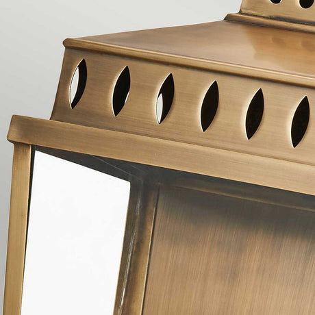 Close-up of the Mansion 2 Light Outdoor Wall Light in aged brass, featuring a solid brass structure with a rectangular glass panel and decorative oval cutouts on top. This IP44-rated outdoor lighting fixture offers a classic, elegant design, ideal for an outdoor wall light.