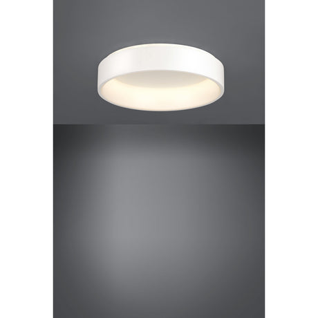 Marghera 1 LED flush ceiling light, 59.5cm round white drum with integrated diffuser, shown illuminated on a grey ceiling and wall in a plain studio setting.