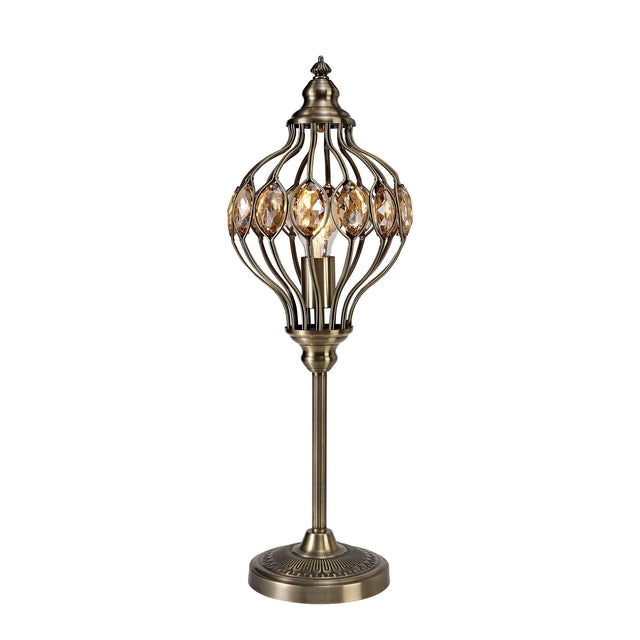The Marisa 1 Light Crystal Table Lamp features an antique brass finish with an openwork metal cage, amber crystal accents, and a round engraved base—evoking the charm of a Middle Eastern lantern.