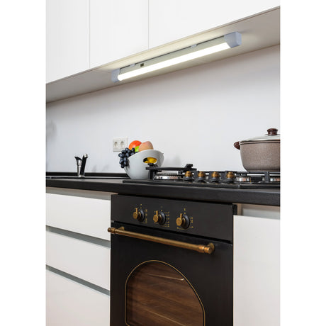 Mattanza LED flush ceiling light, white slim 60cm bar fixture mounted under kitchen wall cabinets above a hob, illuminating the worktop below.