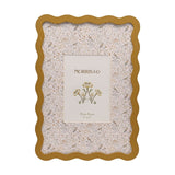Rectangular metal photo frame with a wavy ochre border, holding a cream mount printed with tiny birds, owls and flowers, for a 7 x 5in photo on a white background.