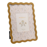Baby Wiggle Bird Print Metal Photo Frame in ochre with a wavy border, holding a 7 x 5in insert over a cream mount patterned with birds and florals, on a white background.