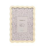 Baby Wiggle rectangular photo frame in cream with a wavy metal border, featuring a botanical mount illustrated with grey florals and animals, shown on a plain white background.