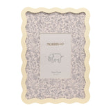Cream metal photo frame with wavy scalloped border and grey botanical mount featuring floral and animal line drawings around a 5"x7" opening.