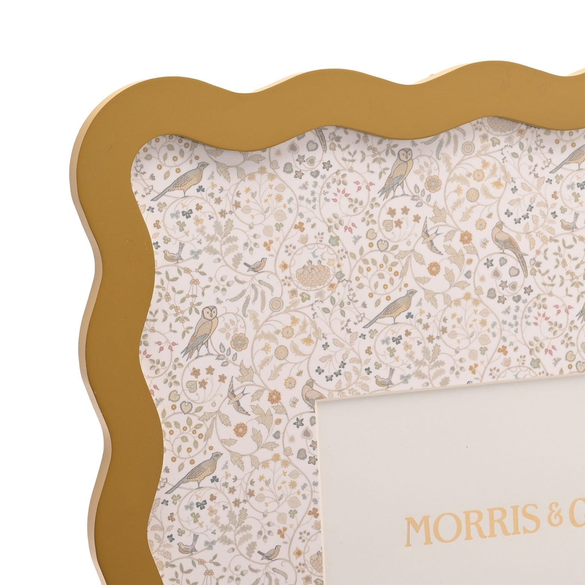 Close-up of the ochre Baby Wiggle photo frame with wavy scalloped border and printed panel of birds, owls and trailing floral pattern, holding a 7 x 5in photo mount.